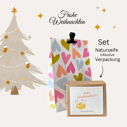 Geschenkset, Geschenkverpackung mit Seifenschachtel, Etikette auf der Schachtel Frohe Weihnachten, goldiges Paket mit Herzen